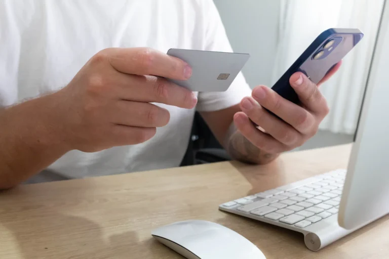 Homem usando cartão e smartphone para pagamento online