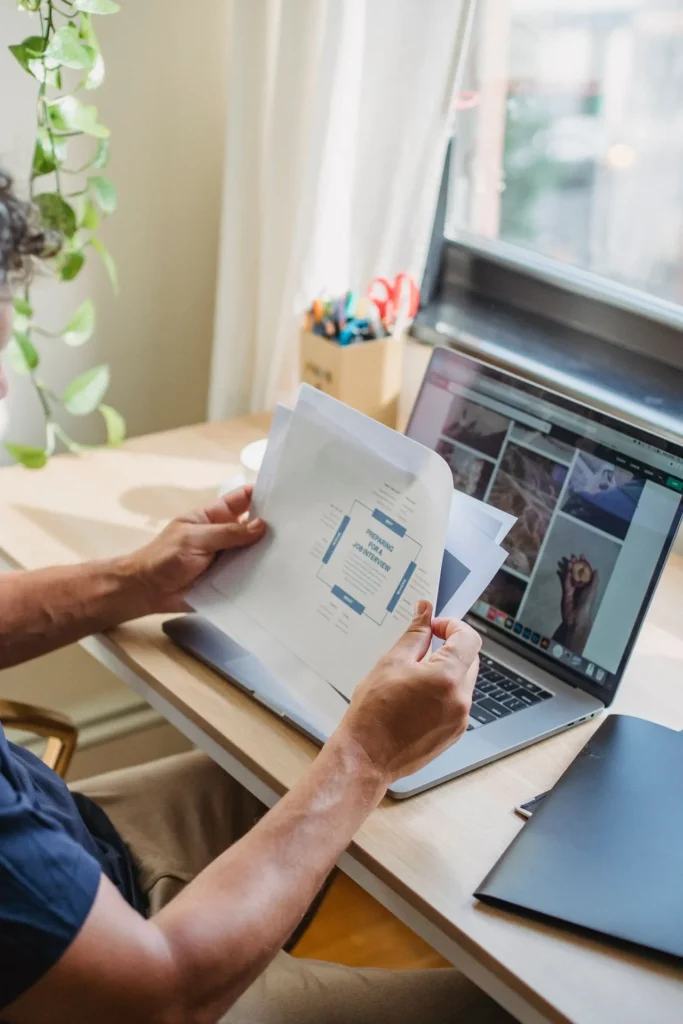 freelancer revisando invoice documentos | Cartão Pré-Pago Internacional Profissional revisando documentos de cobrança em frente ao notebook
