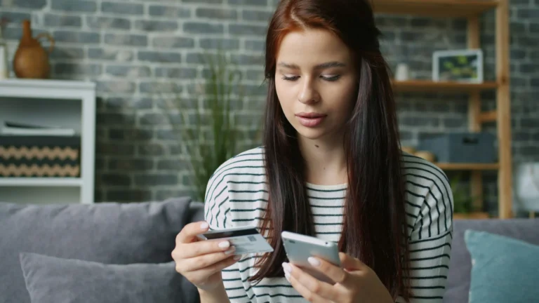 Pessoa usando cartão e smartphone para pagamento online
